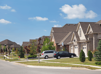 Suburban neighborhood with standalone single-family homes and cars parked in the driveways